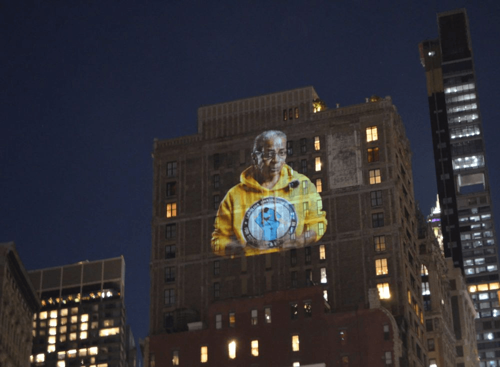 Here are 10-word scroll-stopping headlines:

Worker’s Face ON Bezos Penthouse! Activists Project Powerful Message.
Bezos Penthouse Targeted: Amazon Worker’s Face Projected. Shocking Stunt!
Activists Beam Worker’s Face Onto Bezos Penthouse. Must-See Moment!
Amazon Worker’s Face Invades Bezos’s Penthouse: Epic Activist Protest.
Raleigh Worker’s Face On Bezos Penthouse. Billionaire Confronted Visually.
 | Vibe NC