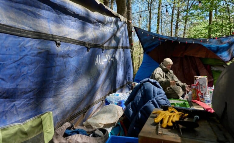 Create a 10-word scroll-stopping headline for: Inside Outlanders, Raleigh’s Self-Governed Homeless Community | Vibe NC