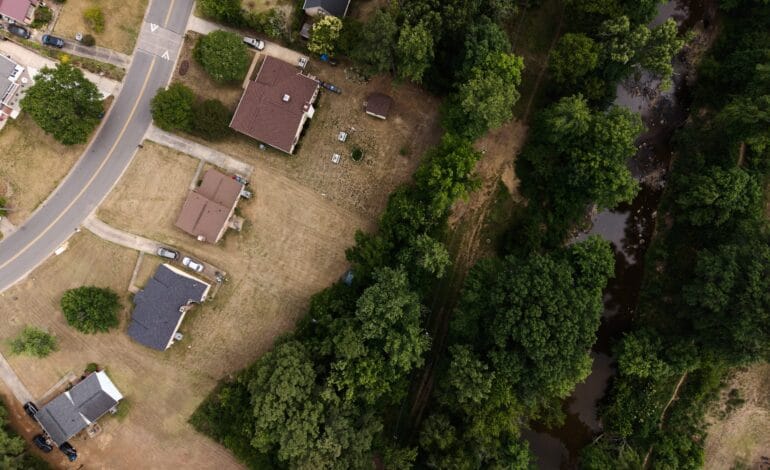 Create a 10-word scroll-stopping headline for: A Year After Chantal, Durham’s Old Farm Neighborhood Is Still Recovering | Vibe NC