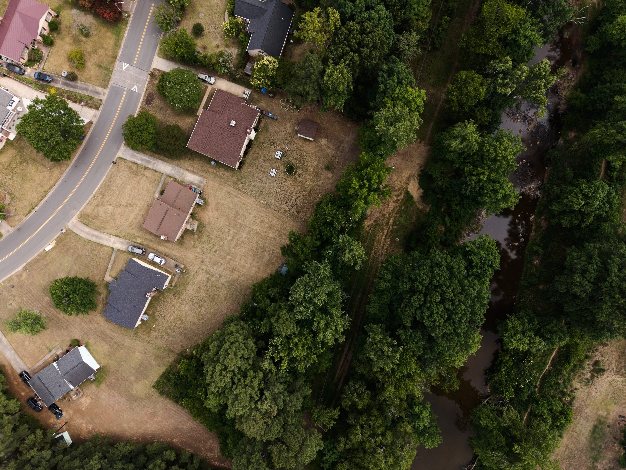 Create a 10-word scroll-stopping headline for: A Year After Chantal, Durham’s Old Farm Neighborhood Is Still Recovering | Vibe NC